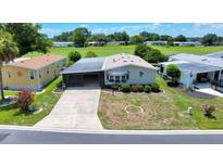 A high-angle view shows the house with a screened-in porch and car port, complemented by lush landscaping and verdant lawn at 926 Saint Andrews Blvd, Lady Lake, FL 32159