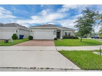 Charming single-story home with a brick-paved driveway and well-manicured lawn at 9380 La Salle St, Groveland, FL 34736