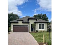 Charming single-story home with a brick driveway, well-manicured lawn, and attached two-car garage at 0 Sunbeam Way, Lady Lake, FL 32159