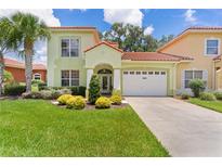 Charming two-story home with a well-manicured lawn, lush landscaping, and a two-car garage at 1055 Avenida Sonoma, Lady Lake, FL 32159