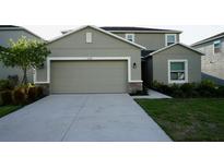 Two-story home featuring an attached two-car garage, neutral paint, and simple landscaping at 1138 Calico Pointe Cir, Groveland, FL 34736