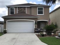 Two-story home with a large garage, stone accents, and a welcoming front porch with seating at 12313 Ne 48Th Loop, Oxford, FL 34484