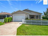 Charming single-story home with a well-maintained lawn and white picket fence at 2311 Pine Ridge St, The Villages, FL 32162