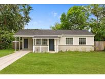 Charming single-story home featuring a well-manicured lawn and welcoming covered entry at 2311 Vincent Rd, Orlando, FL 32817