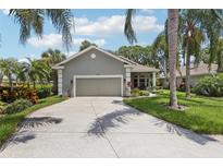 Charming home with a two-car garage, mature palm trees, and a well-manicured lawn at 2512 Baywater Rd, Tavares, FL 32778
