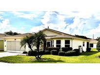Inviting single-story home with well-manicured lawn and lush landscaping, offering great curb appeal at 327 Bentwood Dr, Leesburg, FL 34748