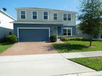 Two-story home featuring a brick driveway and landscaped front yard, offering classic curb appeal at 418 Winter Bliss Ln, Mount Dora, FL 32757