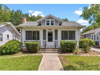 Charming bungalow with a screened front porch and manicured landscaping at 501 Washington Ave, Eustis, FL 32726