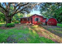 Charming single-story home featuring mature landscaping and a cozy covered porch at 54544 Buckhorn Rd, Astor, FL 32102