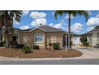 Charming single-story home featuring a landscaped front yard and a well-maintained exterior at 1496 Lime Grove Ln, The Villages, FL 32162