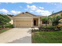 Charming home featuring a two-car garage, landscaped front yard, and covered entryway at 20945 Oldenburg Loop, Mount Dora, FL 32757