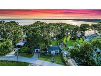 Charming home nestled among mature trees with lake views and vibrant sunset at 30523 Orange Dr, Leesburg, FL 34748