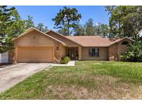 Charming single-story home featuring a brick facade, well-manicured lawn, and attached two-car garage at 3184 Maltby Dr, Deltona, FL 32738