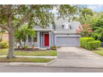 Charming two-story home with a well-manicured lawn, red front door, and an attached two-car garage at 4445 Blue Major Dr, Windermere, FL 34786