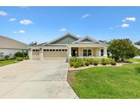 Charming single-story home featuring a well-manicured lawn and a three-car garage at 5311 Eads Ter, The Villages, FL 32163
