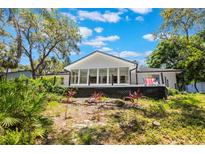 Landscaped backyard showcasing a modern home addition with expansive windows and an outdoor deck at 7921 Sebago Ct, Orlando, FL 32835