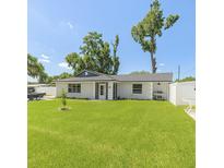 Charming single-story home featuring a manicured lawn, white fence, and inviting entrance at 999 W Juniata St, Clermont, FL 34711