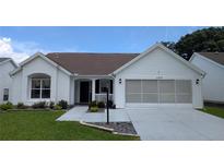 Charming home featuring a well-manicured lawn and a convenient two-car garage at 1105 San Remo Ln, Lady Lake, FL 32159