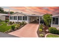 Well-maintained single-story home with a covered carport and lovely landscaped front yard at 11926 Milan Way, Leesburg, FL 34788