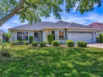Charming single-story home featuring a well-manicured lawn and beautiful landscaping at 1675 Westminster Ct, The Villages, FL 32162