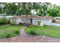 Charming single-story home with a brick pathway and beautiful lawn at 212 Blossom Ln, Winter Park, FL 32789
