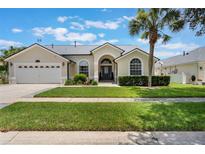 Charming single-story home with a well-manicured lawn, arched windows, and a welcoming front entrance at 3128 Ibis Hill St, Clermont, FL 34714