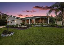 Charming single-story home with a well-manicured lawn and inviting front porch, perfect for relaxing evenings at 318 Stone Castle Loop, Lady Lake, FL 32159