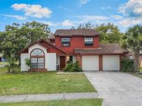 Charming two-story home with a well-maintained lawn and an attached two-car garage at 3904 Valencia Grove Ln, Orlando, FL 32817
