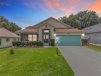 Charming single-story home featuring a well-manicured lawn and a bright blue garage door at 4520 Eaglewood Dr, Leesburg, FL 34748