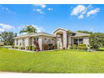 Charming single-story home with a manicured lawn, mature landscaping, and inviting entryway at 5620 Illumination Ln, Leesburg, FL 34748