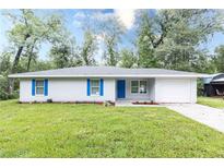 Charming single-story home features a well-maintained lawn, blue shutters, and a matching door at 8161 Cr 647, Bushnell, FL 33513