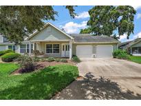 Charming single-story home with a well-manicured lawn, covered porch with swing, and two-car garage at 911 Beverly Harbors Dr # 16, Leesburg, FL 34748