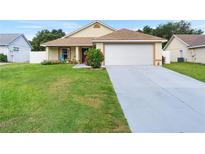 Charming single-story home with a well-maintained lawn, inviting curb appeal, and an attached two-car garage at 10431 Reagans Run Dr, Clermont, FL 34711