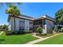 Well-maintained condo with lush landscaping, mature palm trees, and inviting screened in porch at 12 Windtree Ln # 202, Winter Garden, FL 34787