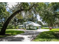 Charming single-story home with mature trees and manicured lawn on a sprawling lot at 168 Pond Rd, Mount Dora, FL 32757