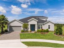 Beautiful single-Gathering home featuring manicured lawn, blue front door, and two car garage at 2161 Cedar Springs Way, Minneola, FL 34715