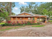 Charming single-story home featuring a cozy porch and well-maintained landscaping and attached covered parking at 25888 Se 157Th Ln, Umatilla, FL 32784