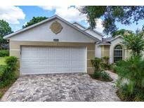 Beautful home exterior featuring a two-car garage with brick driveway and well-maintained landscaping at 3605 Kingswood Ct, Clermont, FL 34711