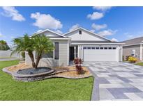 Charming one-story home features a well-manicured lawn and a beautifully designed driveway at 4874 Noreen Ct, The Villages, FL 32163