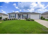 Charming single-story home with well-maintained lawn, tidy landscaping, and inviting curb appeal at 516 Junction Pl, The Villages, FL 32163