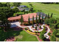 Stunning aerial view of a luxury home featuring a landscaped yard, pool, and tile roof at 5235 Greens Dr, Lady Lake, FL 32159