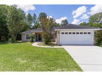 Charming home boasts a well-manicured lawn, inviting walkway, and attached two-car garage at 5460 Sw 103Rd Street Rd, Ocala, FL 34476