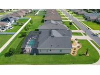 A nice aerial view of the back of the home, showcasing the pool and lush green lawn at 9702 Pepper Tree Pl, Wildwood, FL 34785
