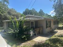 Modest single-story home with a small covered porch and mature landscaping, needs TLC at 11651 Fairmont Ave, Leesburg, FL 34788