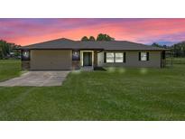 Charming single-story home with a well-manicured lawn and attached two-car garage at 14325 Manchester Ave, Groveland, FL 34736