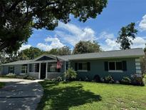 Charming one-story brick home with a covered porch and a well-manicured lawn at 219 Magnolia Cir, Eustis, FL 32726