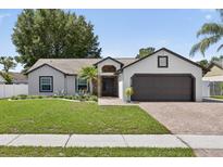Charming single-story home with a well-manicured lawn, brick driveway, and neutral paint scheme at 2834 Bolton Bnd, Orlando, FL 32817