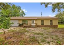 Charming single-story home with a well-maintained yard, front access ramp, and attached garage at 302 W Rose Ln, Lady Lake, FL 32159