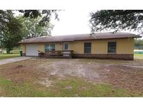 Charming one-story home with a well-manicured lawn and attached garage at 302 W Rose Ln, Lady Lake, FL 32159
