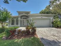 Charming single-story home featuring a two-car garage and beautifully landscaped front yard on a sunny day at 3416 Capland Ave, Clermont, FL 34711
